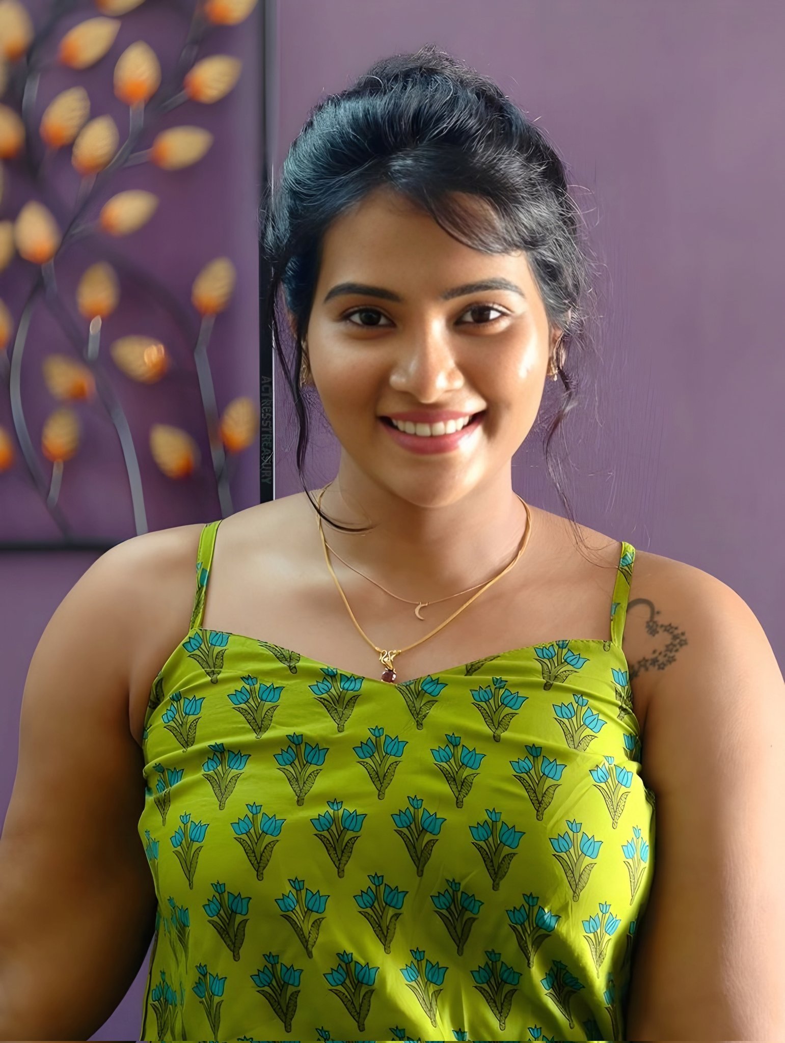 Indian woman wearing green floral top smiling brightly