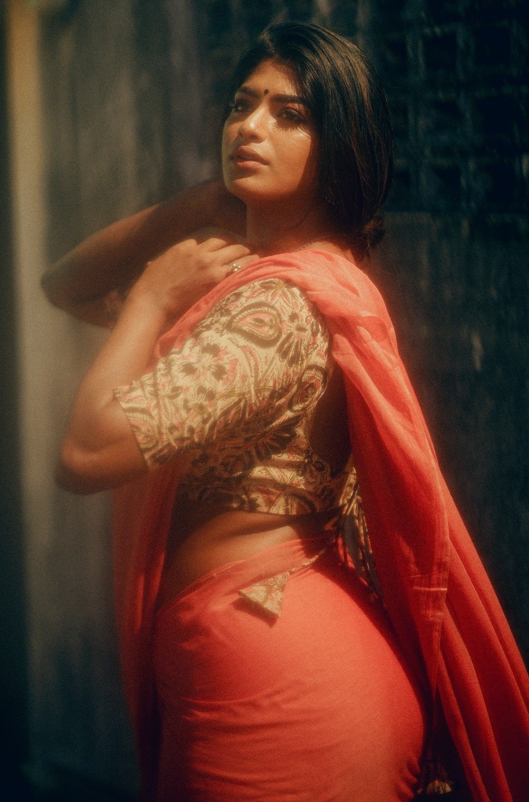 Confident Indian aunty in revealing coral saree posing seductively