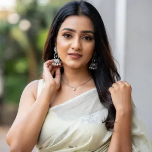 Elegant Indian bhabhi in cream saree with delicate patterns and beautiful jewelry