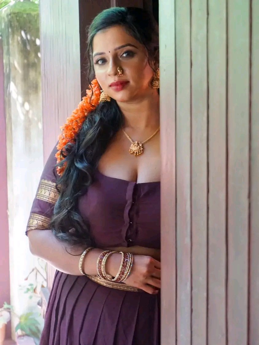 Beautiful South Indian mast maal posing in traditional attire behind wooden door