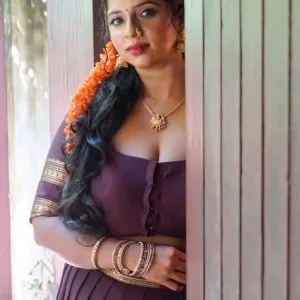 Beautiful South Indian mast maal posing in traditional attire behind wooden door