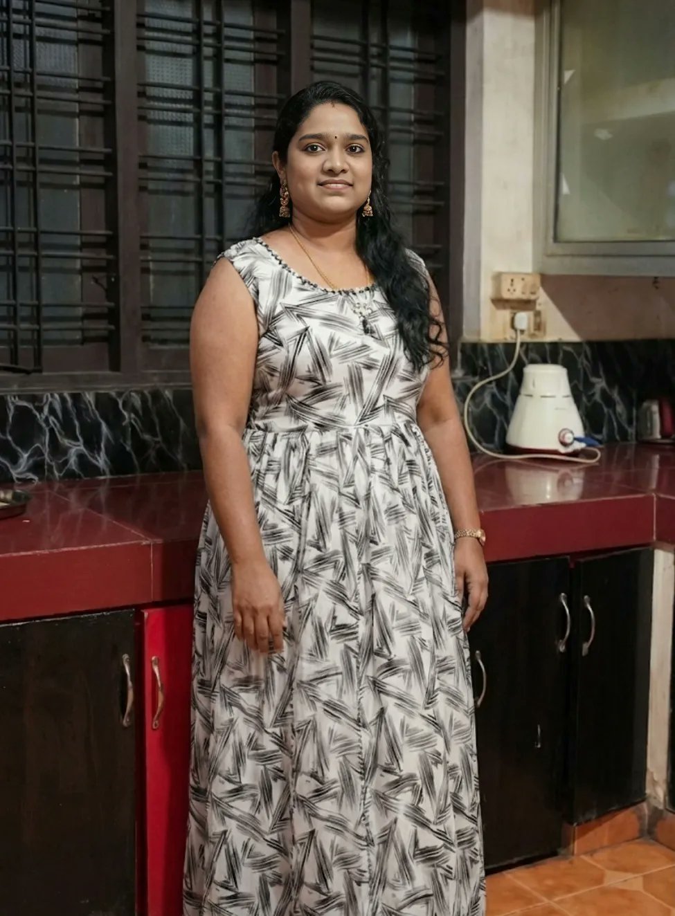 Curvy Indian bhabhi in maxi dress standing in a kitchen
