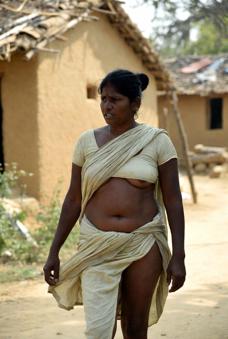 Mature Indian aunty in saree walking in village