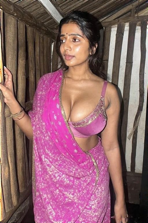 Desi bhabhi in pink saree posing against wooden wall