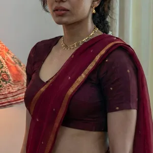 South Indian bhabhi in maroon saree posing with a sultry expression
