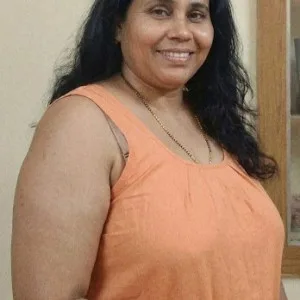 Indian aunty in orange top smiling casually