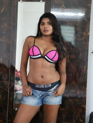 Indian woman in pink Calvin Klein bra demonstrating confidence indoors