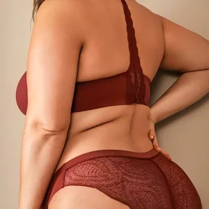 Curvy woman in red lace lingerie posing confidently