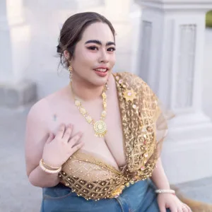 Captivating Indian bhabhi wearing gold blouse and jeans posing outdoors confidently